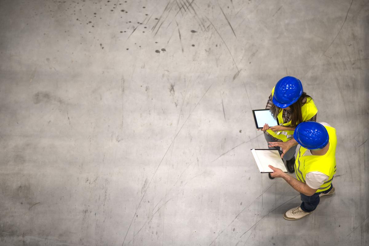 Two construction workers looking at tablets